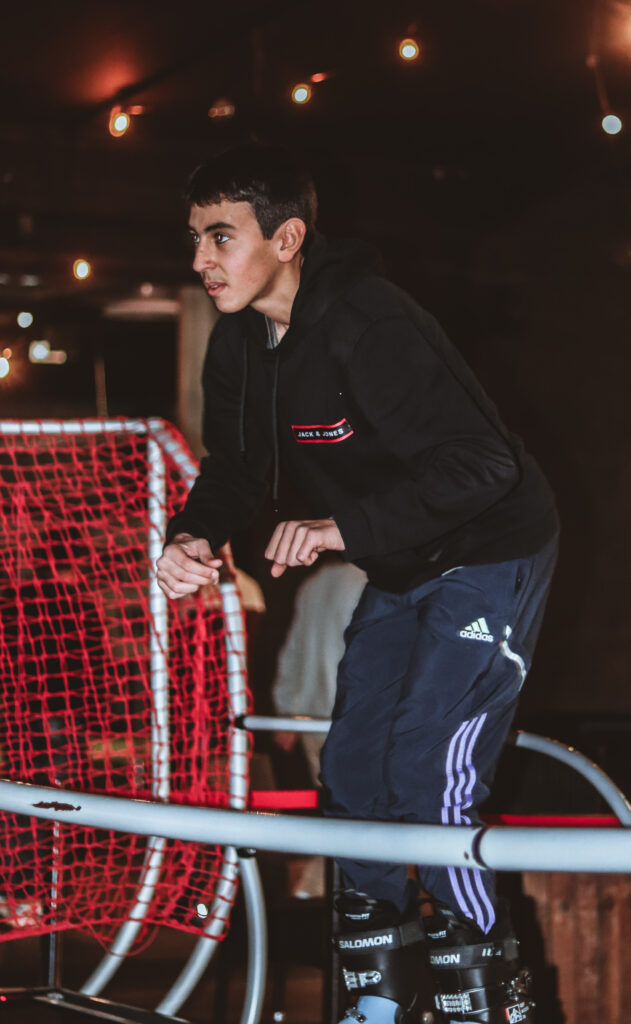 Personne patinant devant un filet rouge.