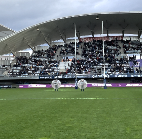 Match de rugby avec public, deux joueurs en bulles.