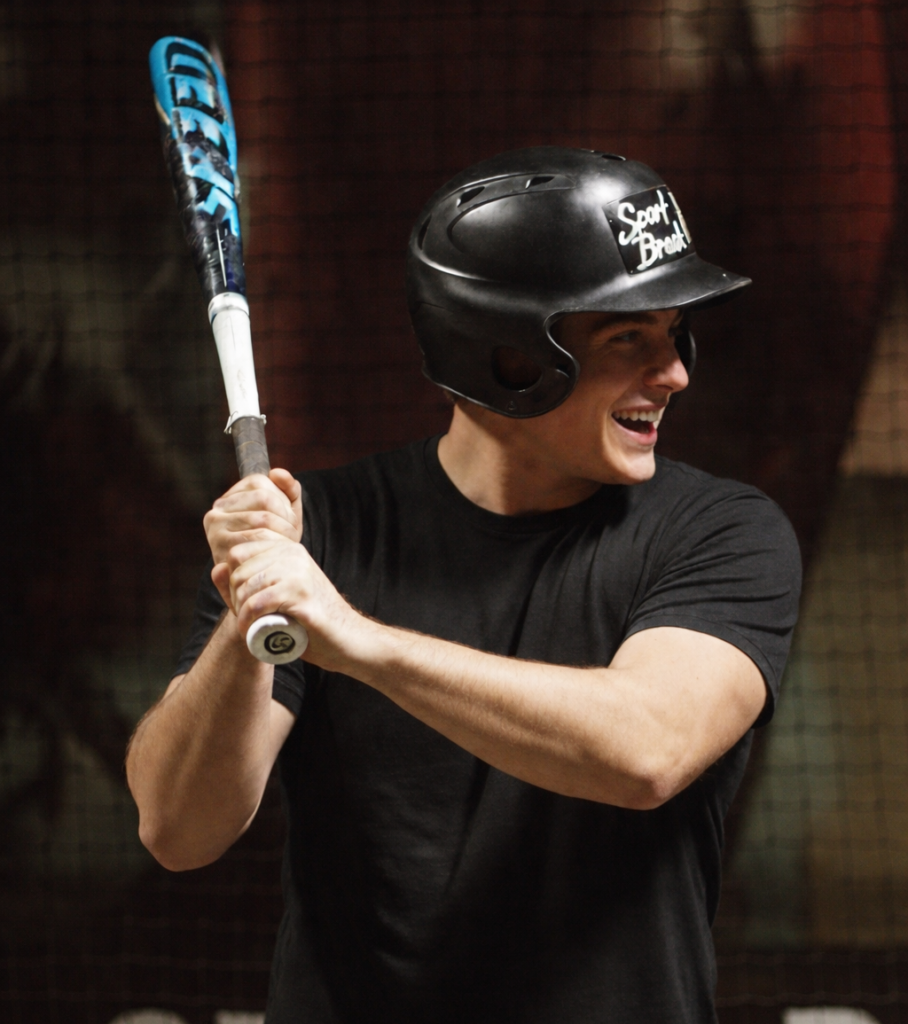 Homme jouant au baseball avec casque et batte.