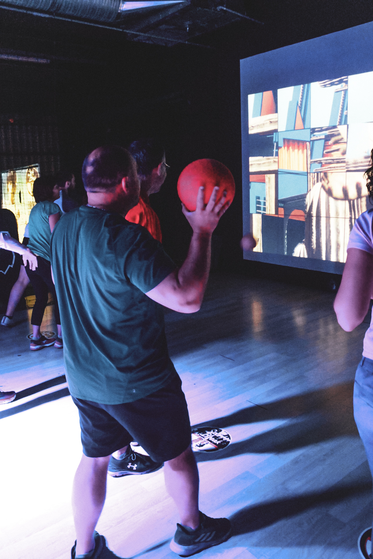 Personne jouant au ballon devant un écran interactif.