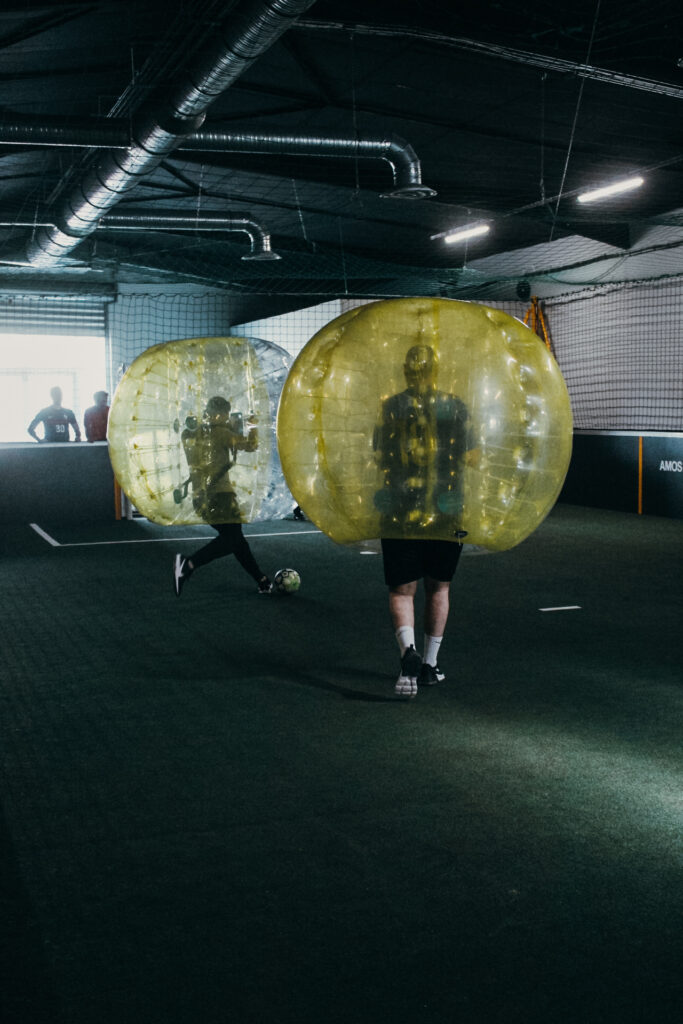 Personnes jouent au football en bulles gonflables.