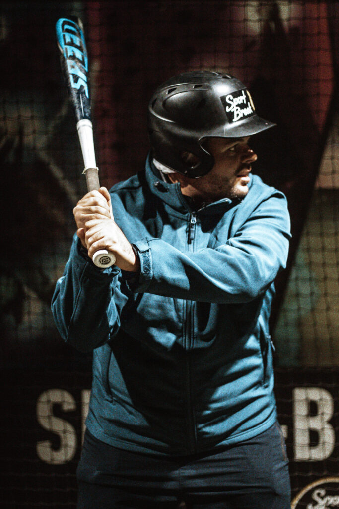 Homme jouant au baseball en intérieur.