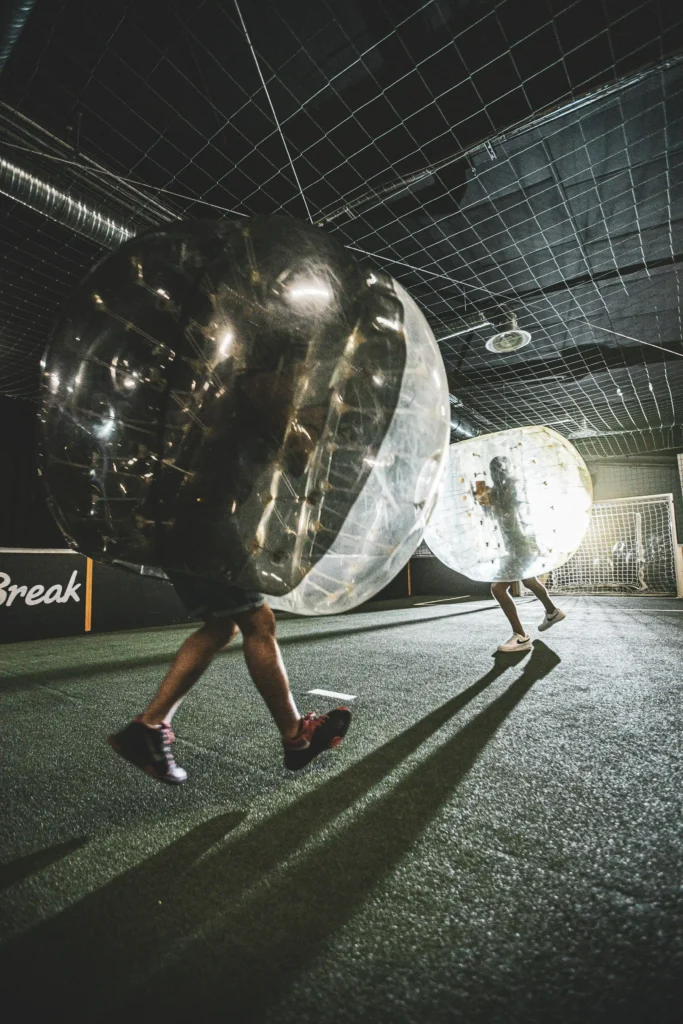 Personnes jouant au bubble football en intérieur.