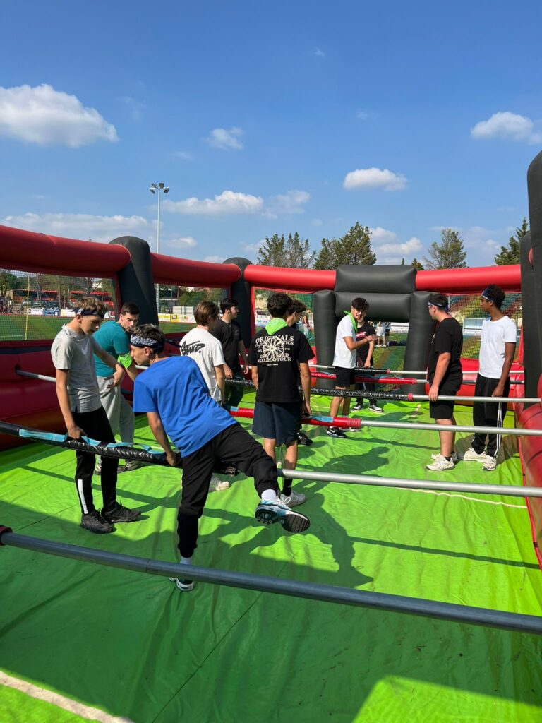Jeunes jouant à un baby-foot humain gonflable.