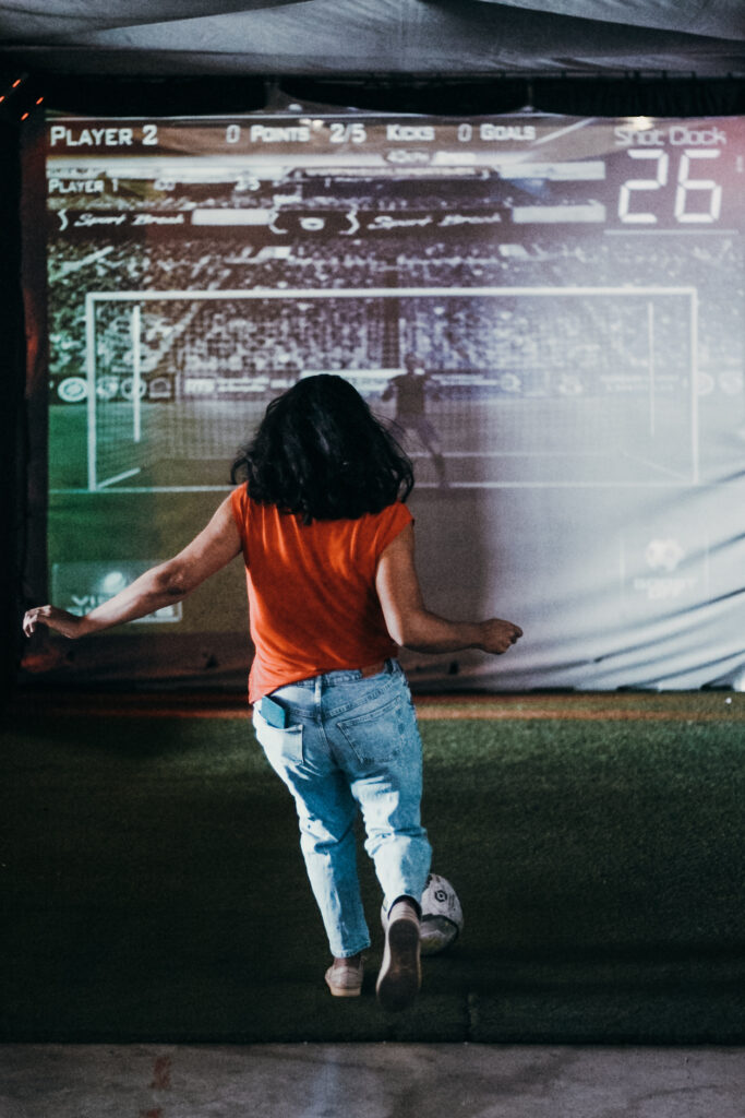 Jeune femme joue au football intérieur interactif.